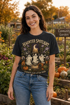Woman wearing a washed black Haunted Spotlight Garden Club Halloween graphic T-shirt in a garden