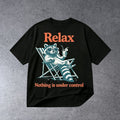 RELAX NOTHING IS UNDER CONTROL FUNNY RACCOON GRAPHIC T-SHIRT on light gray concrete